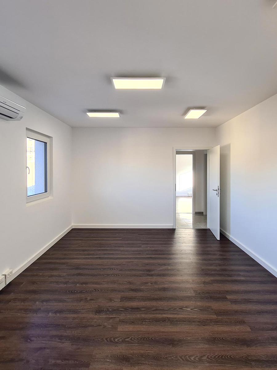 Der Vinylfußboden in diesem Bürogebäude ist fertig verlegt und die Räume sind geweiß gestrichen