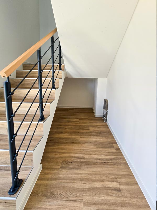 fertig gestrichenes Treppenhaus mit Fußboden und Geländer